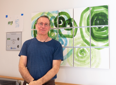 Artist Daniel Kohn posing next to his artwork at Lancaster General Health's Proton Therapy Center